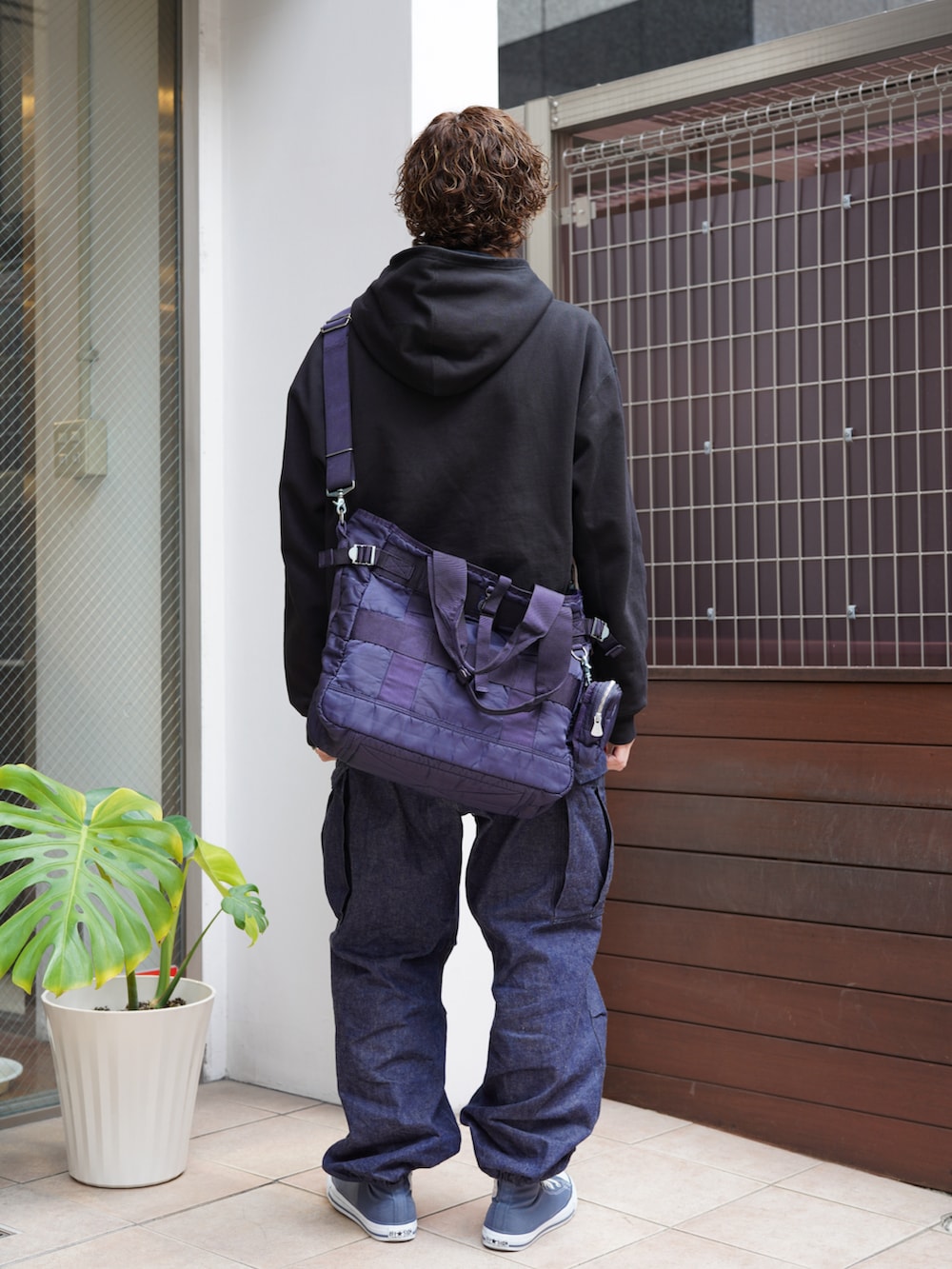 ブラック系のパーカー、ブルー系のカーゴパンツ、ブルー系のスニーカーを着用したメンズの冬コーディネートの3枚目の写真