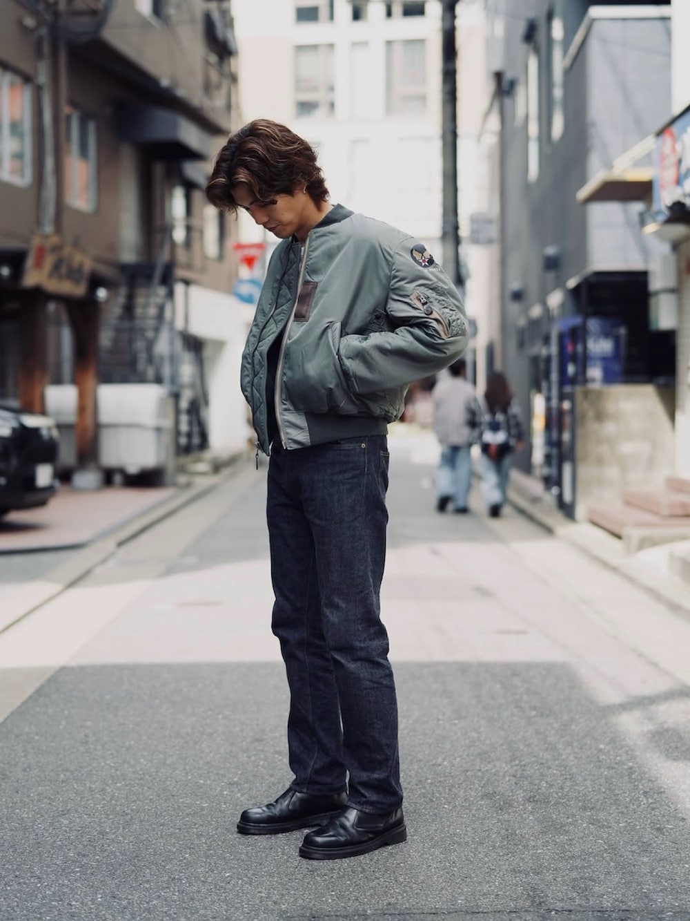 グリーン系のMA-1、ブルー系のデニムパンツを着用したメンズの冬コーディネートの2枚目の写真