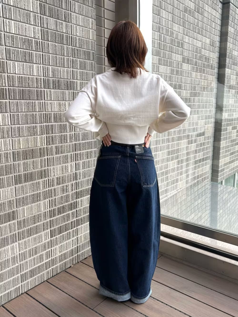 ホワイト系のカーディガン/ボレロ、ブルー系のデニムパンツを着用したレディースの冬コーディネートの3枚目の写真