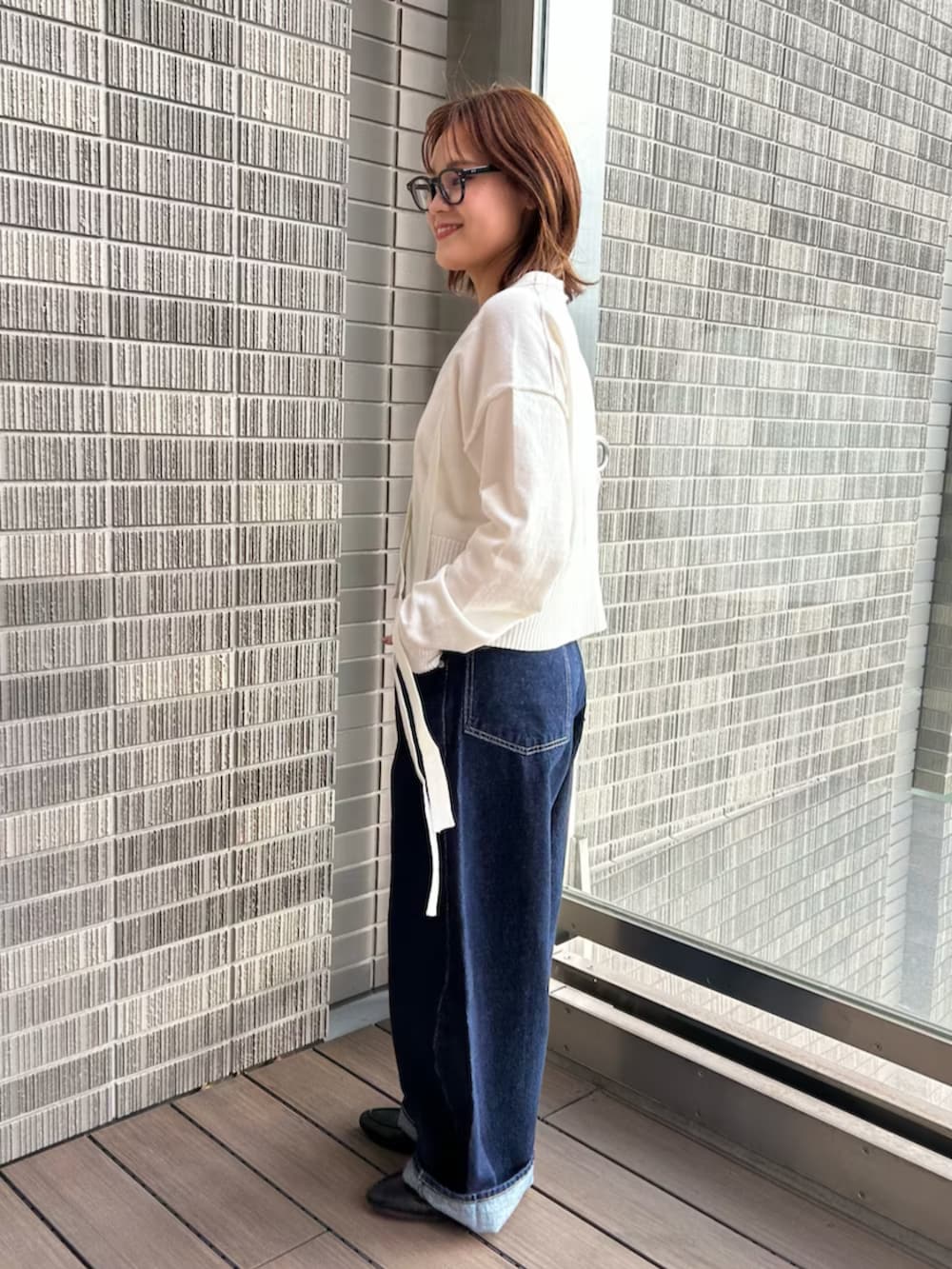 ホワイト系のカーディガン/ボレロ、ブルー系のデニムパンツを着用したレディースの冬コーディネートの2枚目の写真