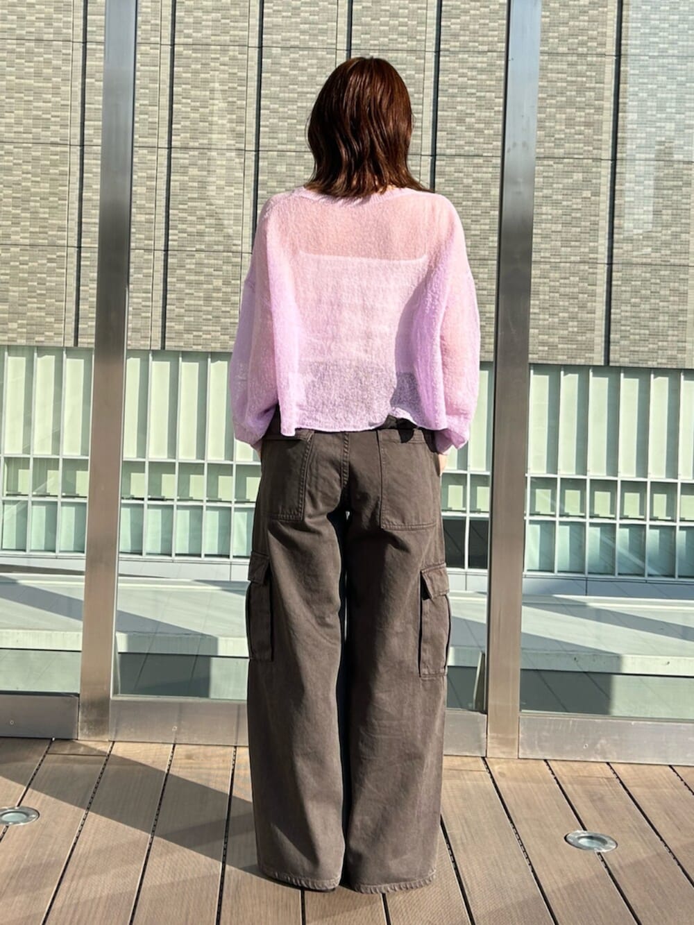 ブラウン系のカーゴパンツ、パープル系のニット/セーターを着用したレディースの春コーディネートの3枚目の写真