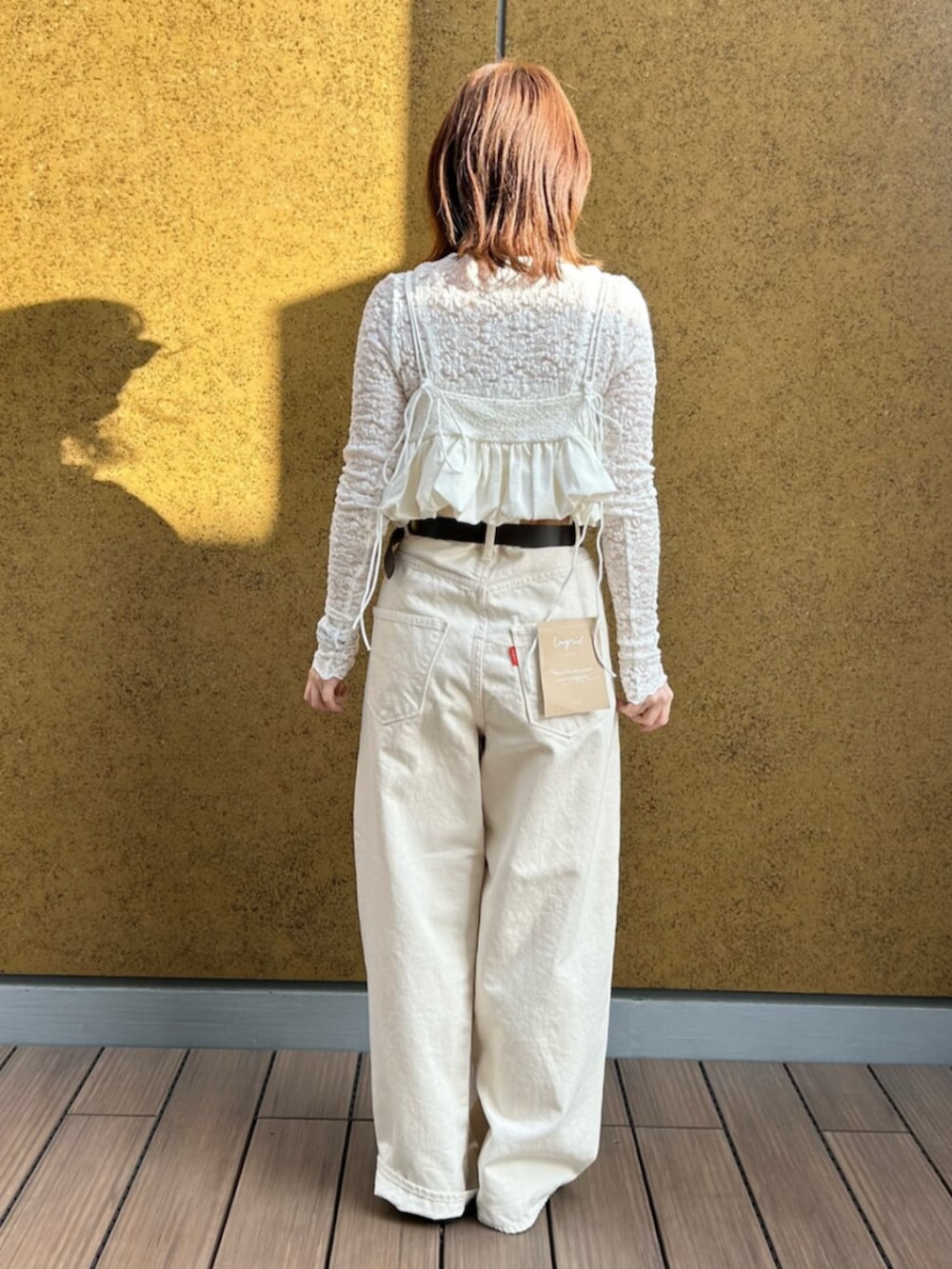 ホワイト系のデニムパンツ、ホワイト系のキャミソール、ホワイト系のTシャツ/カットソーを着用したレディースの冬コーディネートの3枚目の写真