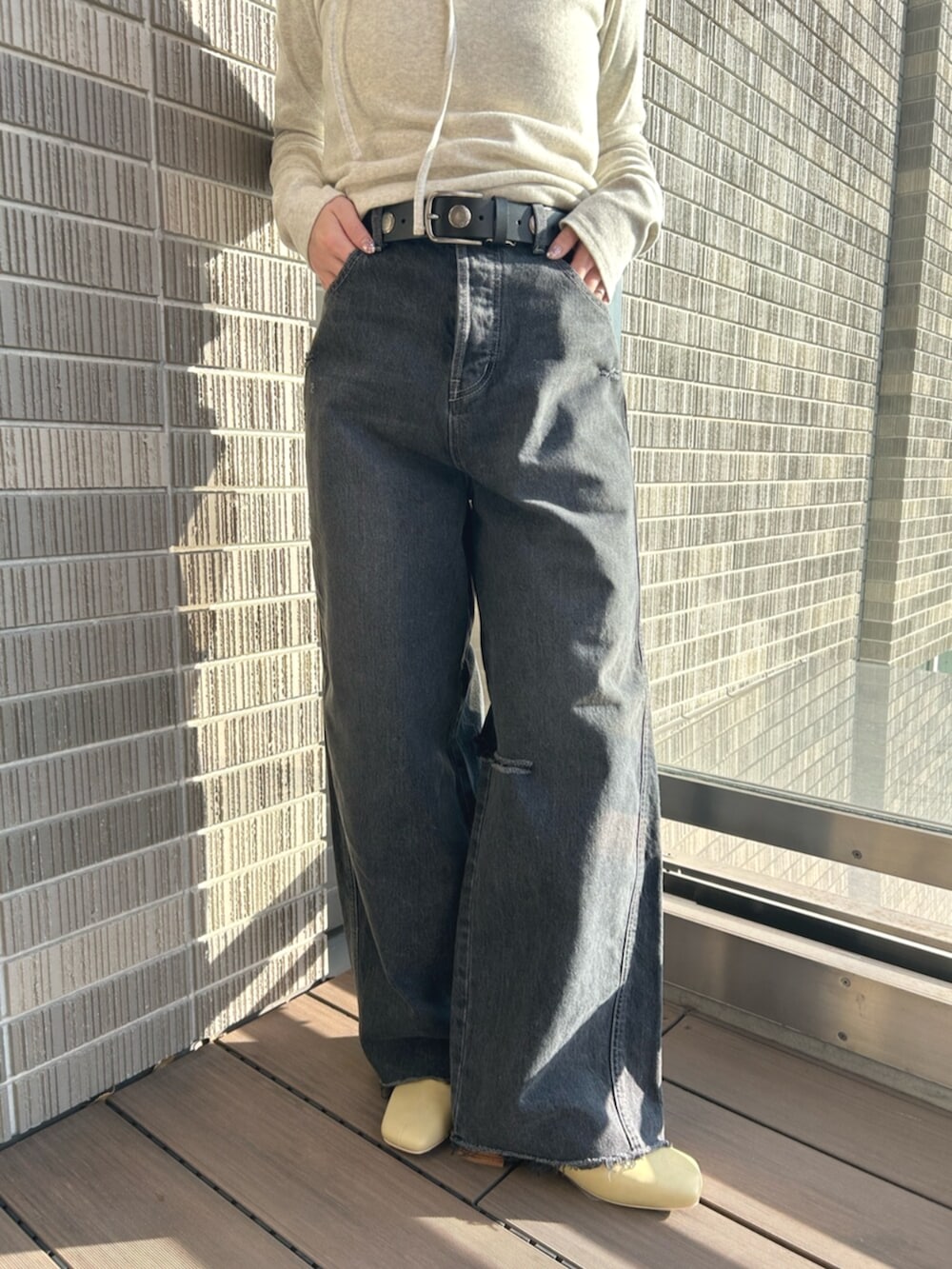 ブラック系のデニムパンツ、グレー系のTシャツ/カットソー、イエロー系のサンダルを着用したレディースの春コーディネートの5枚目の写真