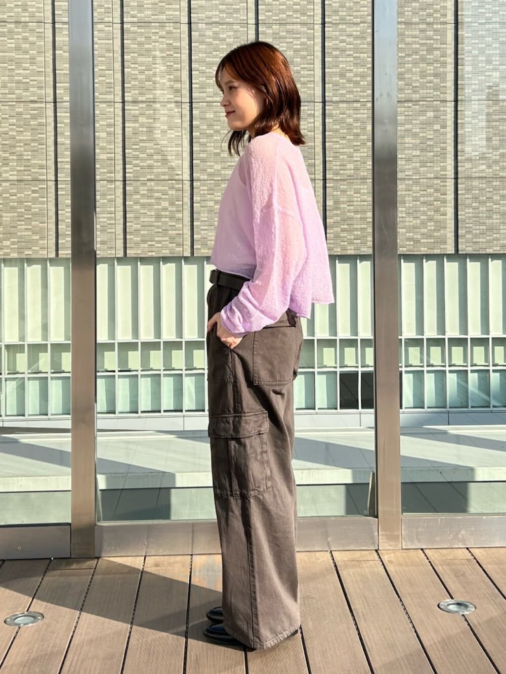 ブラウン系のカーゴパンツ、パープル系のニット/セーターを着用したレディースの春コーディネートの2枚目の写真