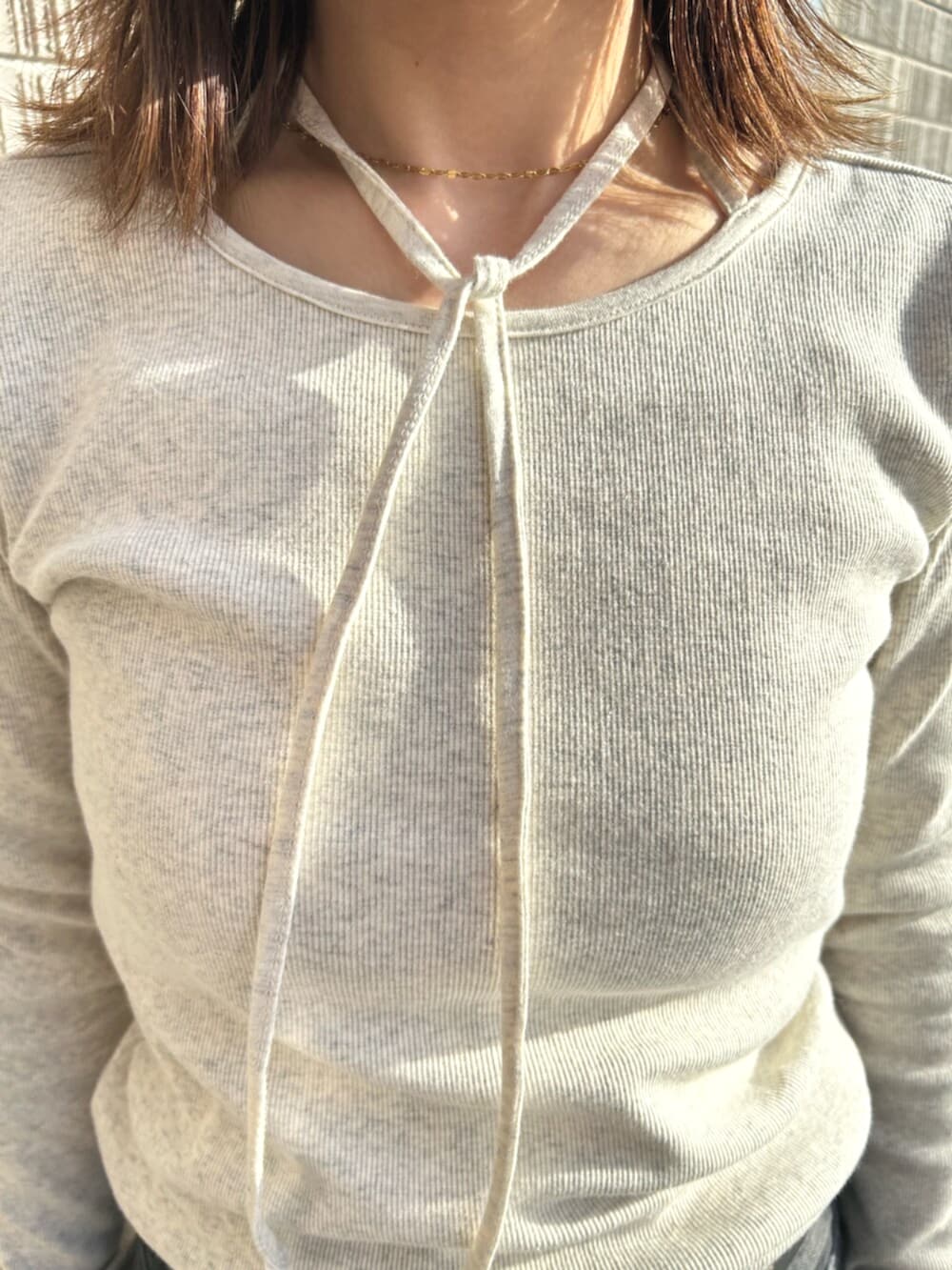 ブラック系のデニムパンツ、グレー系のTシャツ/カットソー、イエロー系のサンダルを着用したレディースの春コーディネートの4枚目の写真