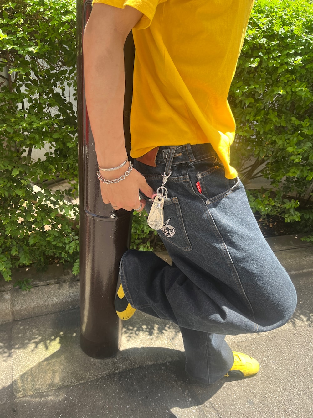 イエロー系のスニーカー、イエロー系のTシャツ/カットソー、ブルー系のデニムパンツを着用したメンズの秋コーディネートの2枚目の写真