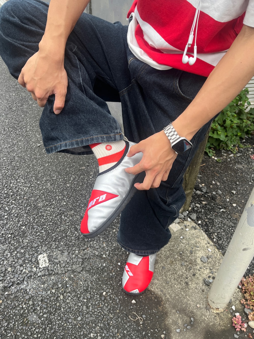レッド系のTシャツ/カットソー、ブルー系のデニムパンツ、レッド系のスリッポンを着用したメンズの秋コーディネートの2枚目の写真