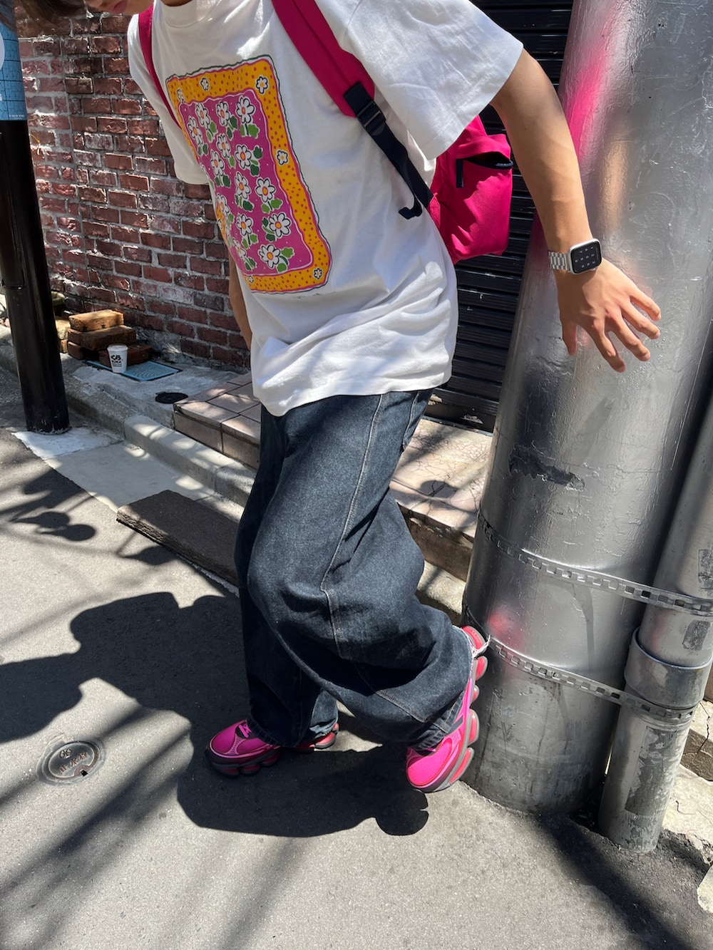 ピンク系のスニーカー、ホワイト系のTシャツ/カットソー、ブルー系のデニムパンツを着用したメンズの秋コーディネートの2枚目の写真