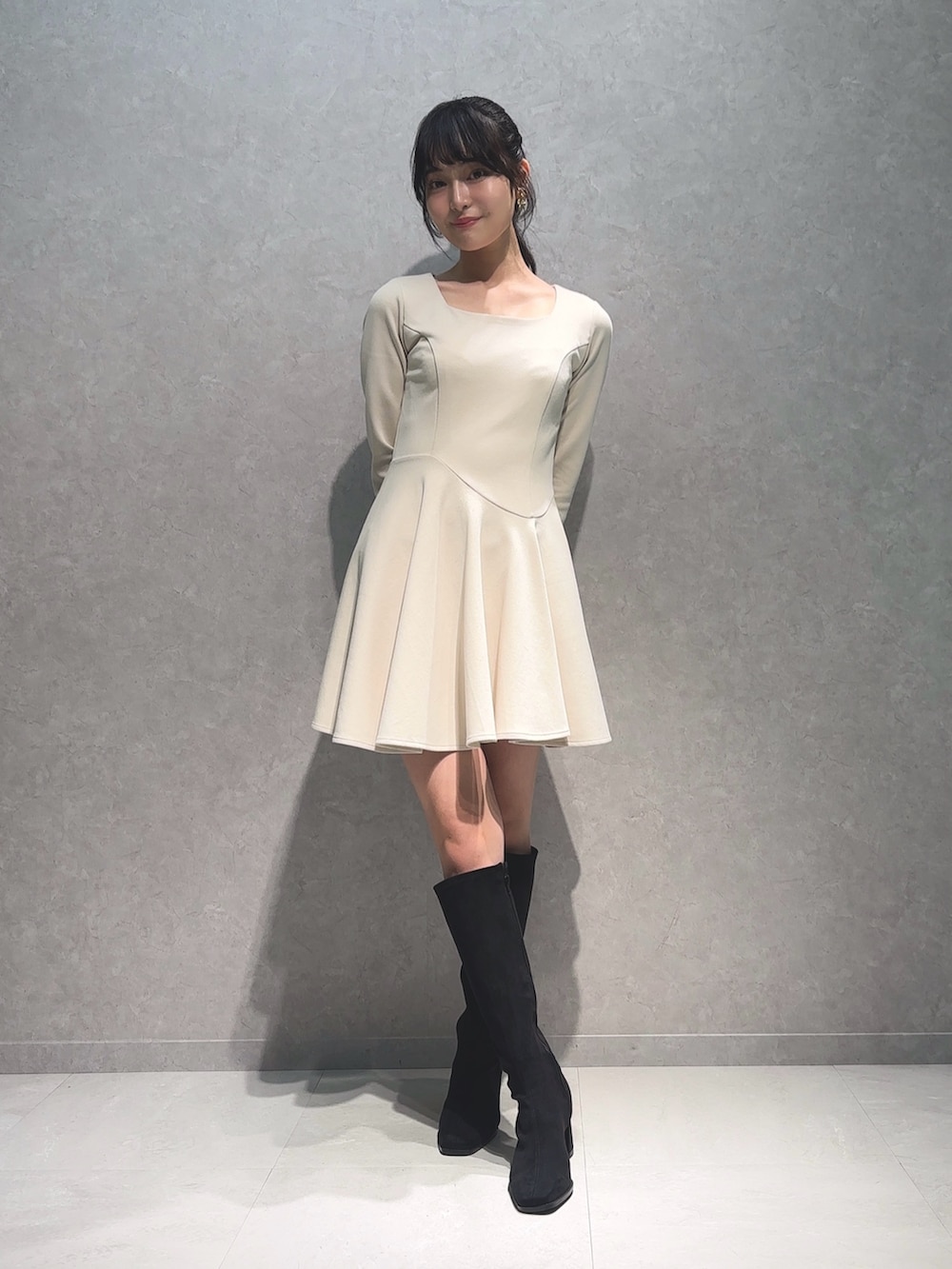 ホワイト系のワンピース、ブラック系のブーツを着用したレディースの秋コーディネートの2枚目の写真