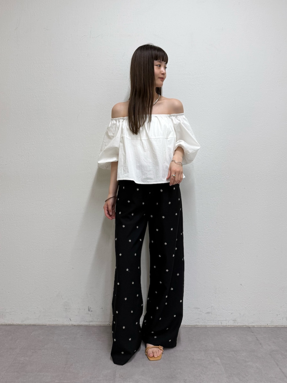 ホワイト系のシャツ/ブラウス、ブラック系のスラックス、ベージュ系のサンダルを着用したレディースの春コーディネートの2枚目の写真