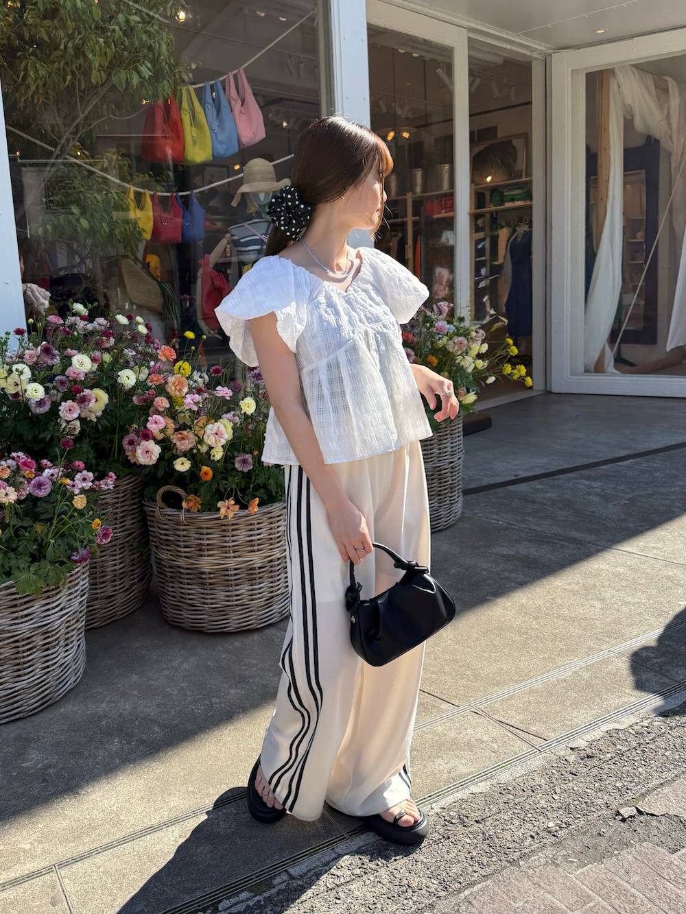 ホワイト系のシャツ/ブラウス、ホワイト系のその他パンツ、ブラック系のトートバッグを着用したレディースの春コーディネートの2枚目の写真