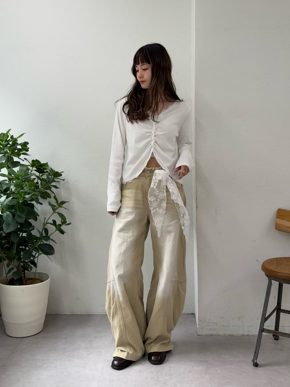 ホワイト系のTシャツ/カットソー、ベージュ系のデニムパンツ、ブラウン系のブーツを着用したレディースの春コーディネートの5枚目の写真