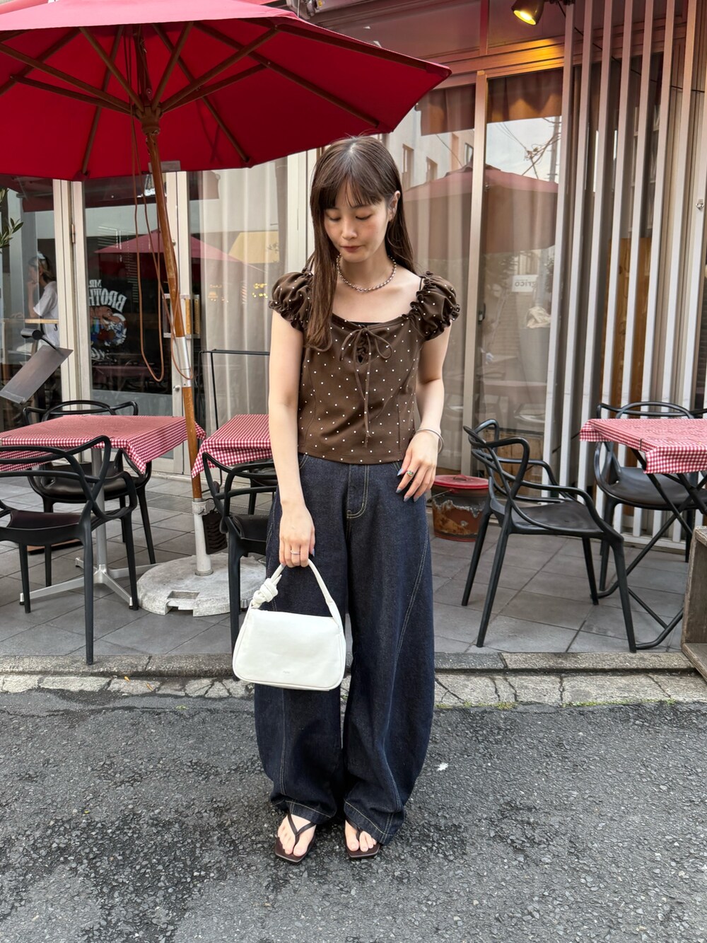 ブラウン系のTシャツ/カットソー、ブラック系のキャミソール、ホワイト系のトートバッグを着用したレディースの夏コーディネートの2枚目の写真
