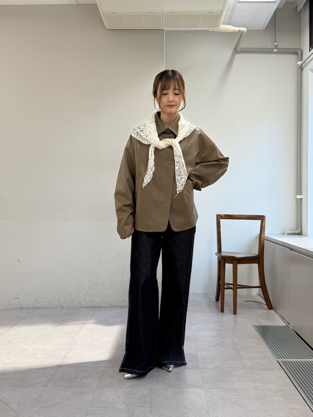 ブラウン系のブルゾン、ブルー系のデニムパンツ、シルバー系のパンプスを着用したレディースの春コーディネートの2枚目の写真