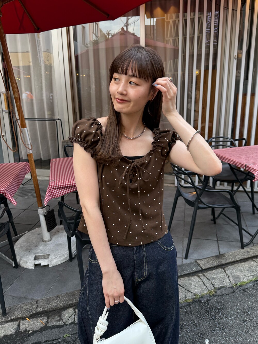 ブラウン系のTシャツ/カットソー、ブラック系のキャミソール、ホワイト系のトートバッグを着用したレディースの夏コーディネートの4枚目の写真