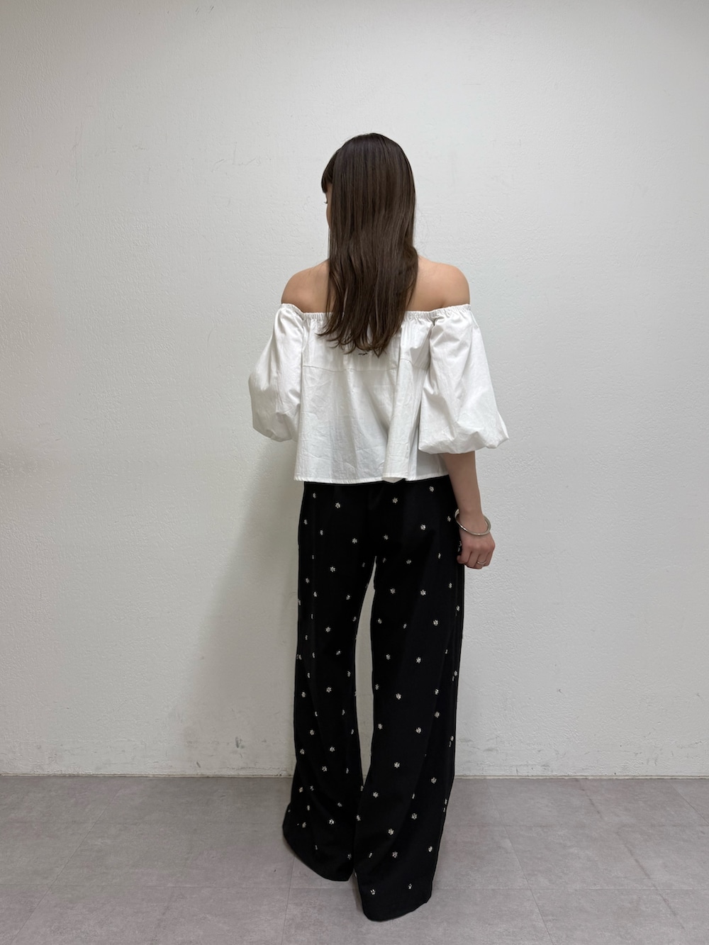 ホワイト系のシャツ/ブラウス、ブラック系のスラックス、ベージュ系のサンダルを着用したレディースの春コーディネートの3枚目の写真