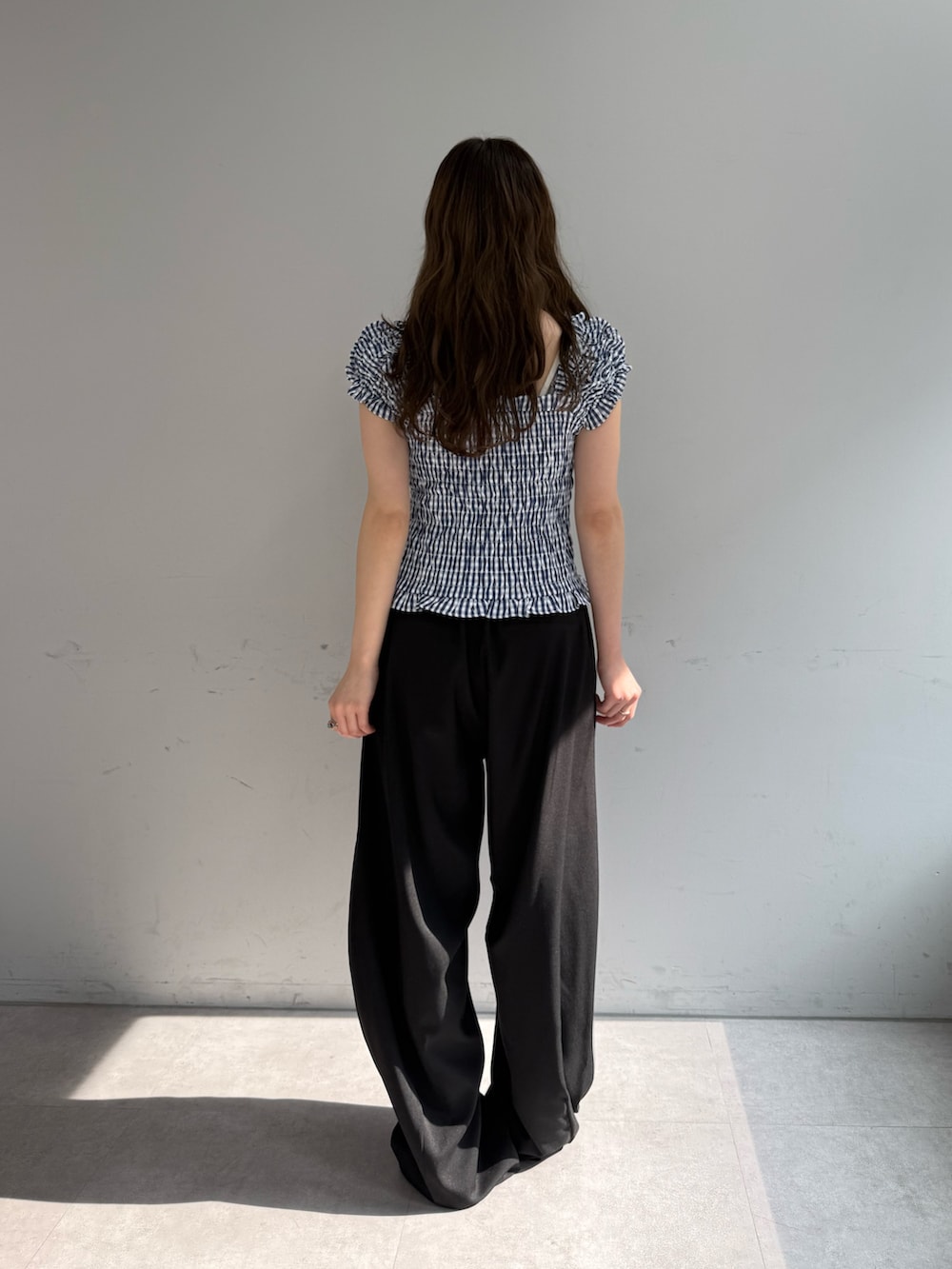 ブルー系のシャツ/ブラウス、ブラック系のスラックス、ブラック系のパンプスを着用したレディースの春コーディネートの3枚目の写真