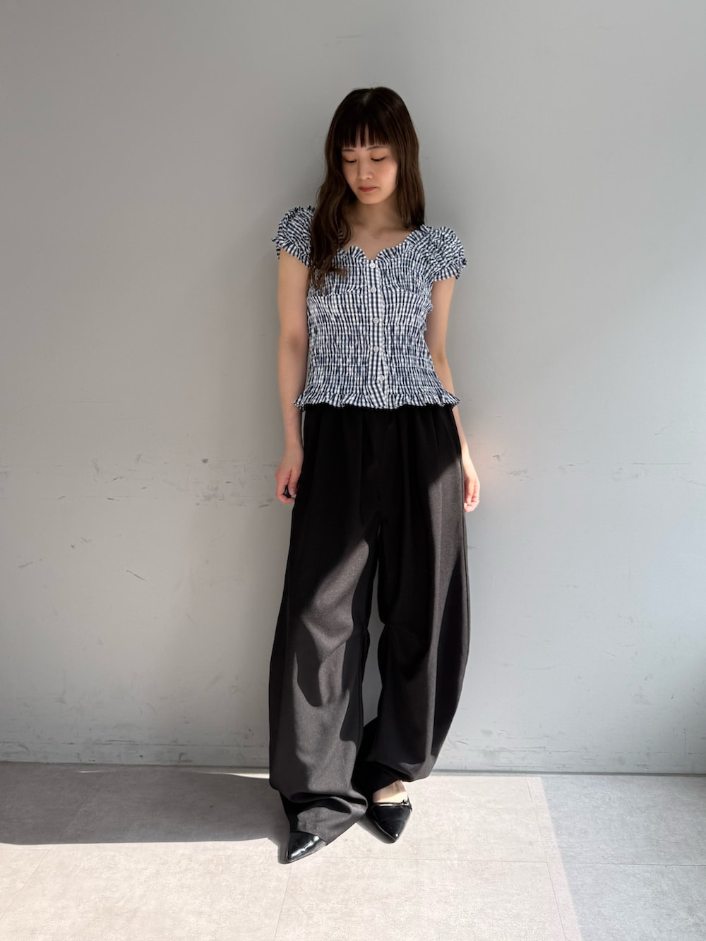 ブルー系のシャツ/ブラウス、ブラック系のスラックス、ブラック系のパンプスを着用したレディースの春コーディネートの2枚目の写真