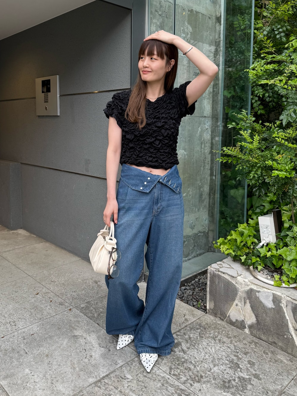 ブラック系のTシャツ/カットソー、ブルー系のデニムパンツ、ホワイト系のその他シューズを着用したレディースの春コーディネートの6枚目の写真