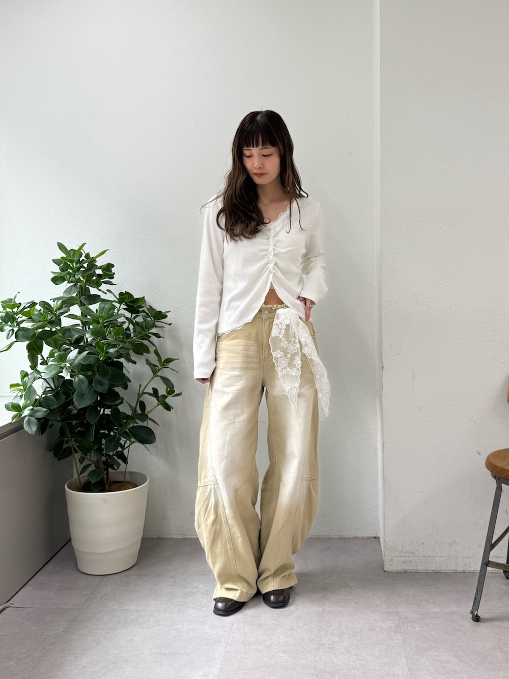 ホワイト系のTシャツ/カットソー、ベージュ系のデニムパンツ、ブラウン系のブーツを着用したレディースの春コーディネートの2枚目の写真