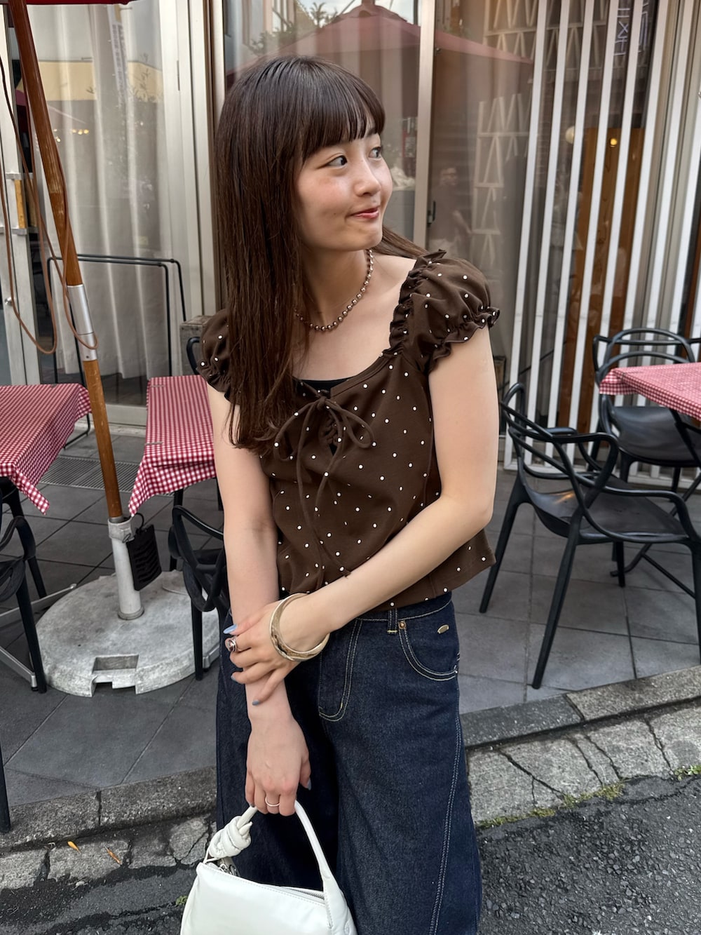 ブラウン系のTシャツ/カットソー、ブラック系のキャミソール、ホワイト系のトートバッグを着用したレディースの夏コーディネートの3枚目の写真