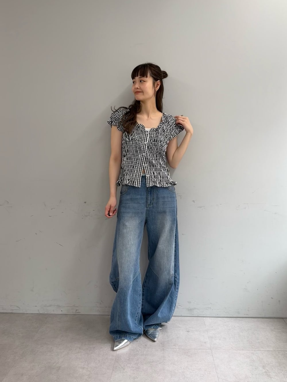 ブラック系のシャツ/ブラウス、ブルー系のデニムパンツ、シルバー系のパンプスを着用したレディースの春コーディネートの4枚目の写真