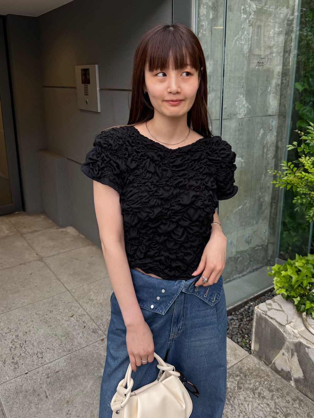 ブラック系のTシャツ/カットソー、ブルー系のデニムパンツ、ホワイト系のその他シューズを着用したレディースの春コーディネートの5枚目の写真