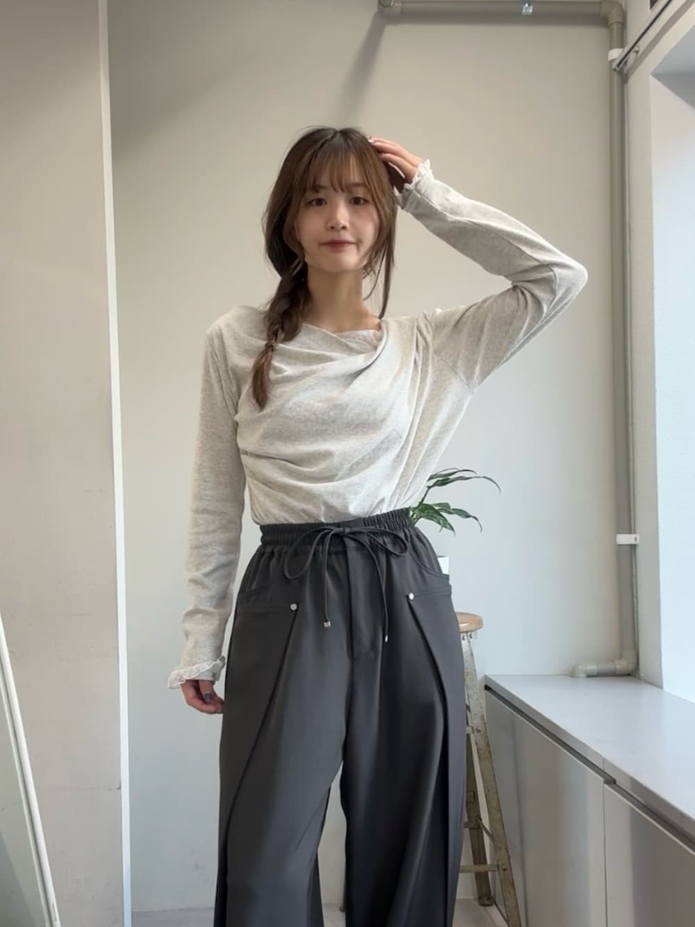 グレー系のTシャツ/カットソー、グレー系のその他パンツ、ブラック系のブーツを着用したレディースの冬コーディネートの4枚目の写真