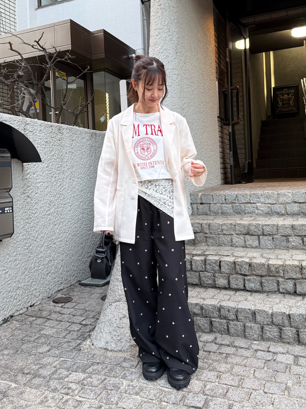 ブラック系のその他パンツ、ホワイト系のその他アウター、ブラック系のその他シューズを着用したレディースの冬コーディネートの2枚目の写真