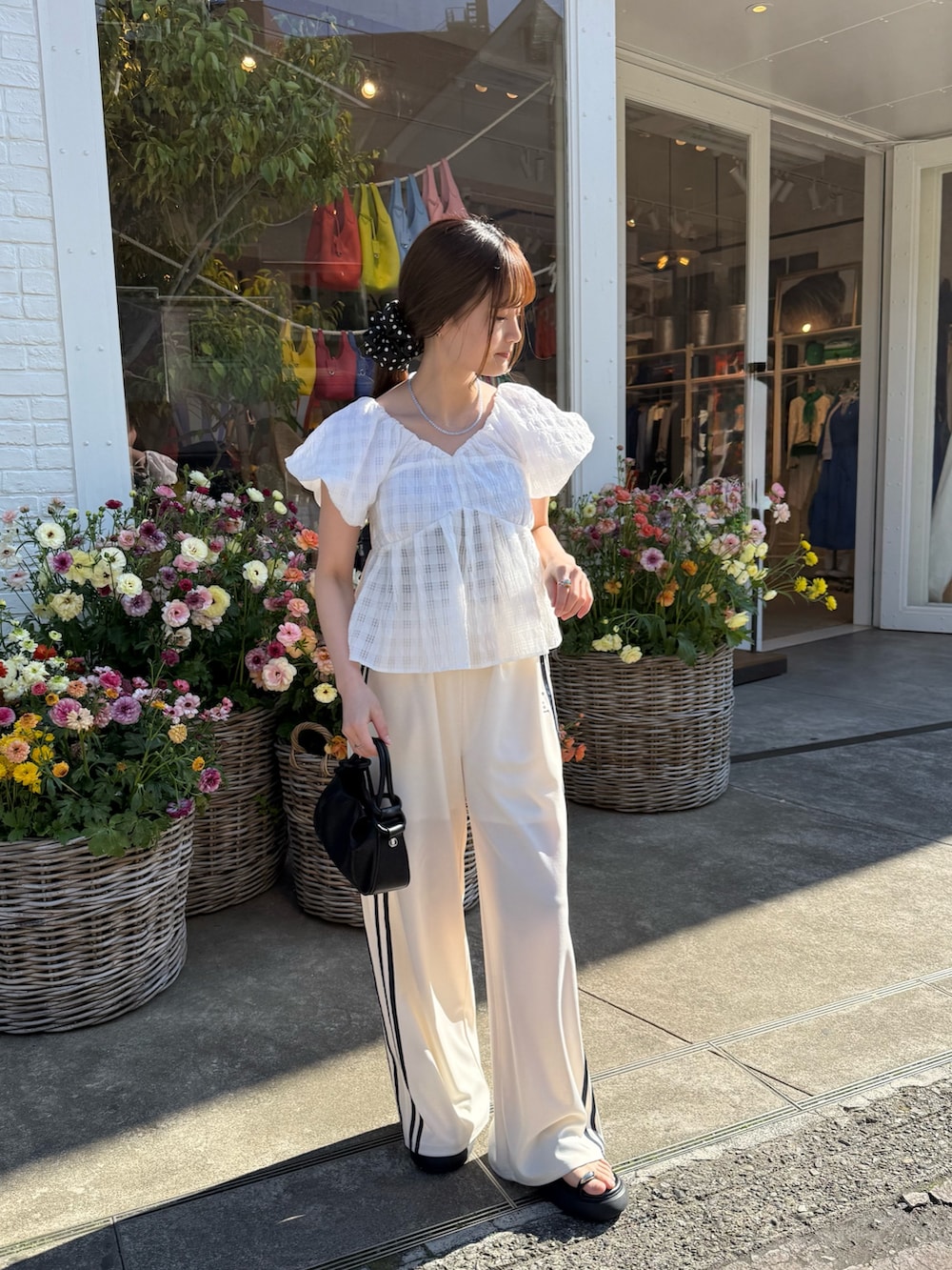 ホワイト系のシャツ/ブラウス、ホワイト系のその他パンツ、ブラック系のトートバッグを着用したレディースの春コーディネートの5枚目の写真