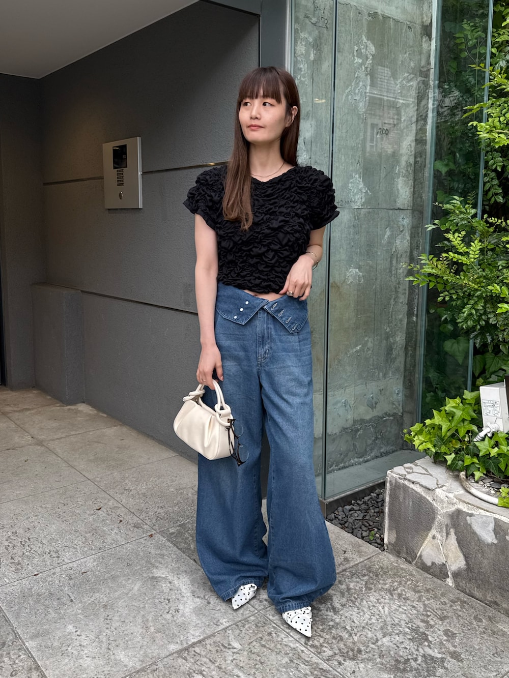 ブラック系のTシャツ/カットソー、ブルー系のデニムパンツ、ホワイト系のその他シューズを着用したレディースの春コーディネートの3枚目の写真
