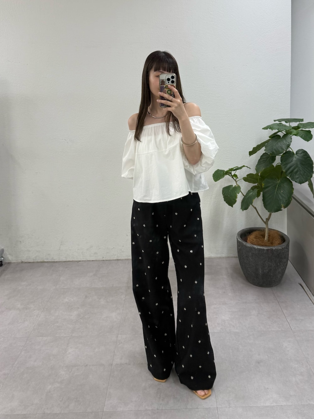 ホワイト系のシャツ/ブラウス、ブラック系のスラックス、ベージュ系のサンダルを着用したレディースの春コーディネートの4枚目の写真