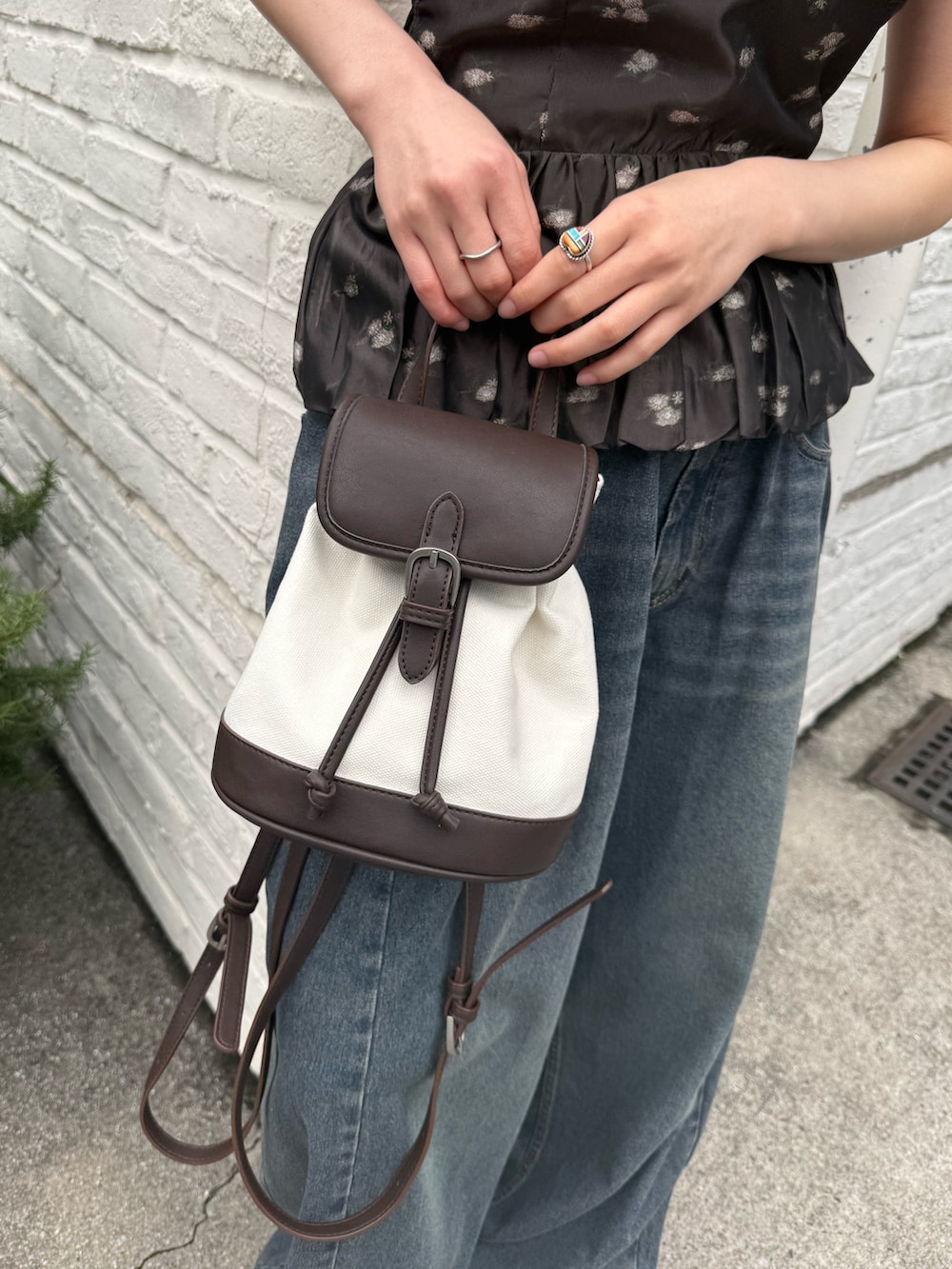 ブラック系のシャツ/ブラウス、ホワイト系のキャップを着用したレディースの春コーディネートの6枚目の写真