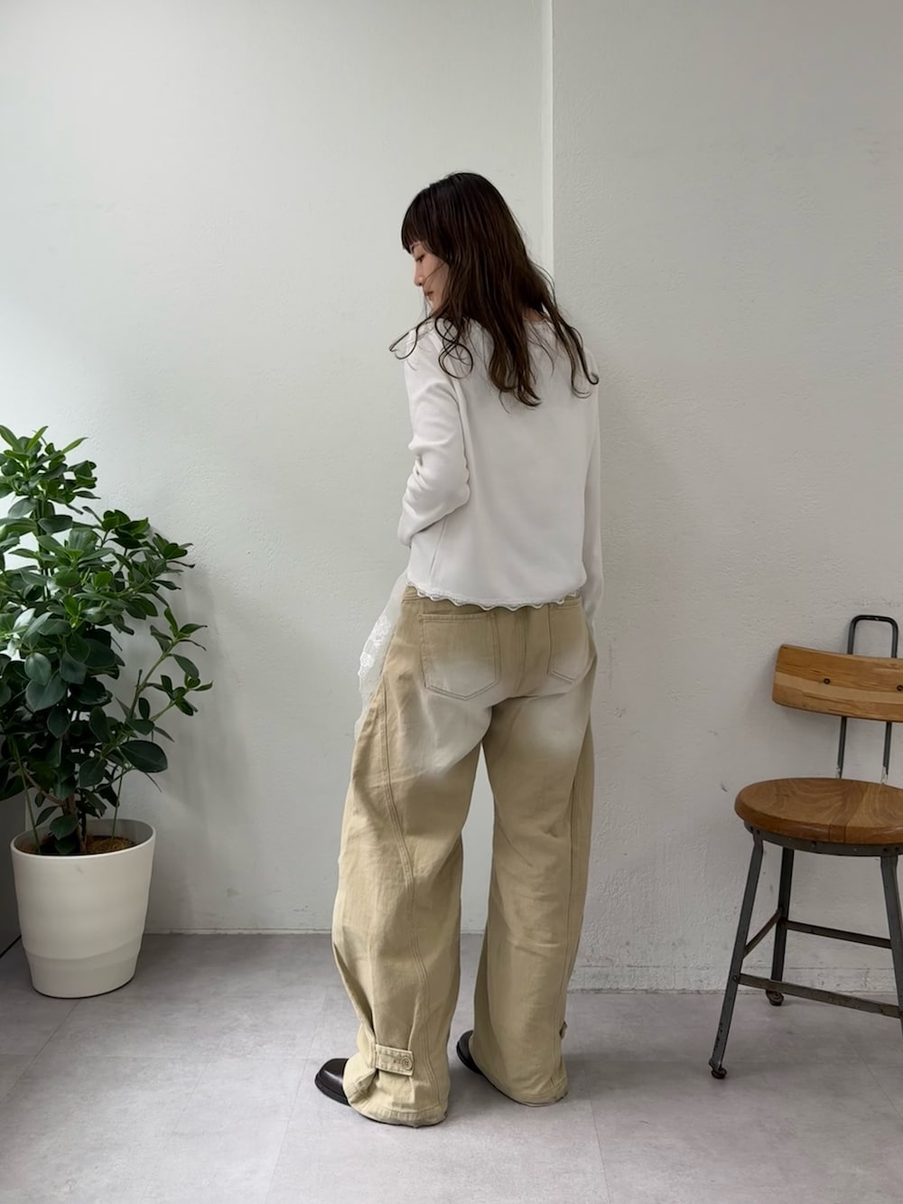 ホワイト系のTシャツ/カットソー、ベージュ系のデニムパンツ、ブラウン系のブーツを着用したレディースの春コーディネートの4枚目の写真