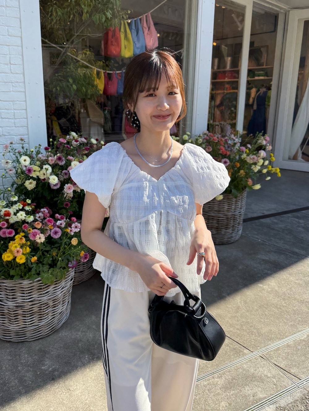 ホワイト系のシャツ/ブラウス、ホワイト系のその他パンツ、ブラック系のトートバッグを着用したレディースの春コーディネートの4枚目の写真