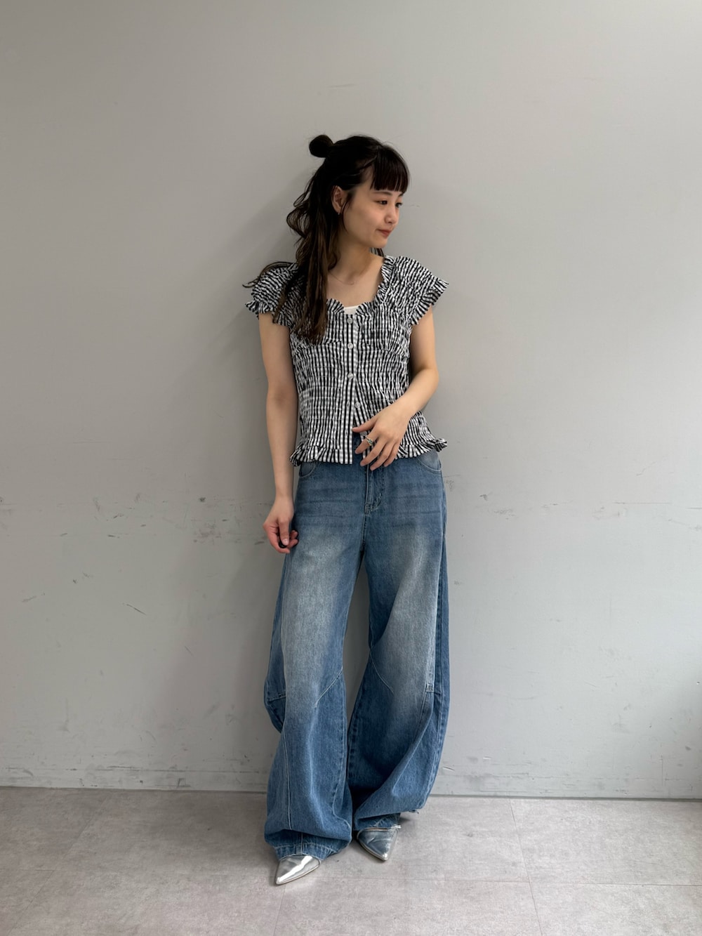 ブラック系のシャツ/ブラウス、ブルー系のデニムパンツ、シルバー系のパンプスを着用したレディースの春コーディネートの3枚目の写真