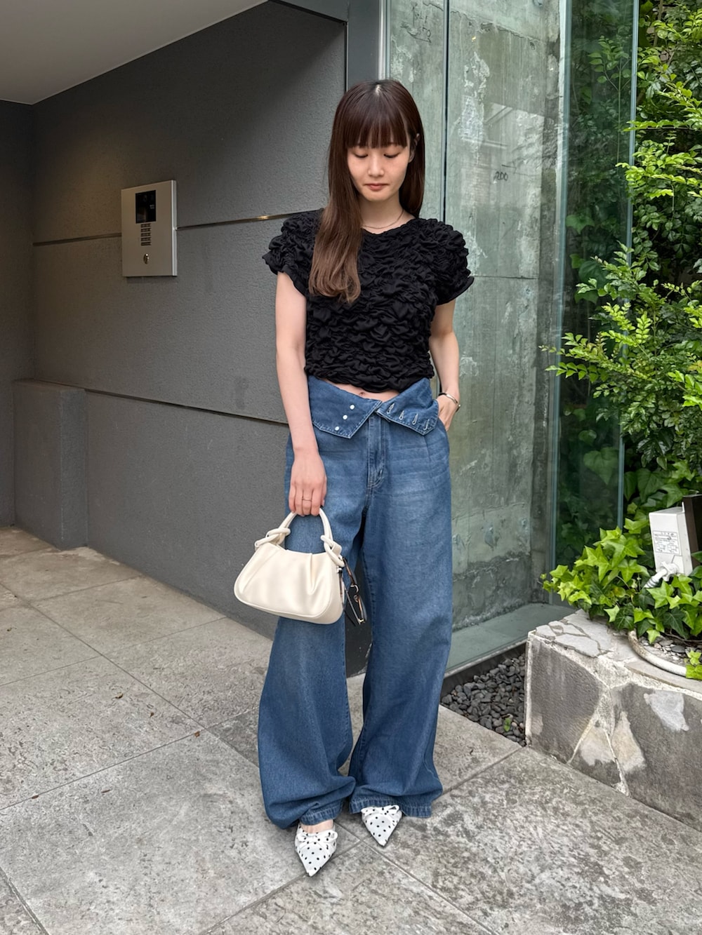 ブラック系のTシャツ/カットソー、ブルー系のデニムパンツ、ホワイト系のその他シューズを着用したレディースの春コーディネートの2枚目の写真