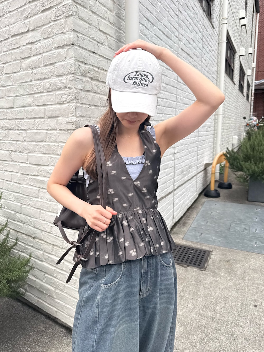 ブラック系のシャツ/ブラウス、ホワイト系のキャップを着用したレディースの春コーディネートの4枚目の写真