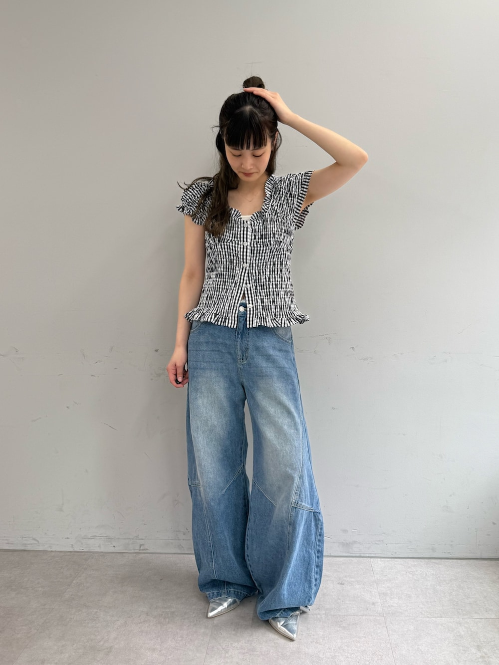 ブラック系のシャツ/ブラウス、ブルー系のデニムパンツ、シルバー系のパンプスを着用したレディースの春コーディネートの2枚目の写真