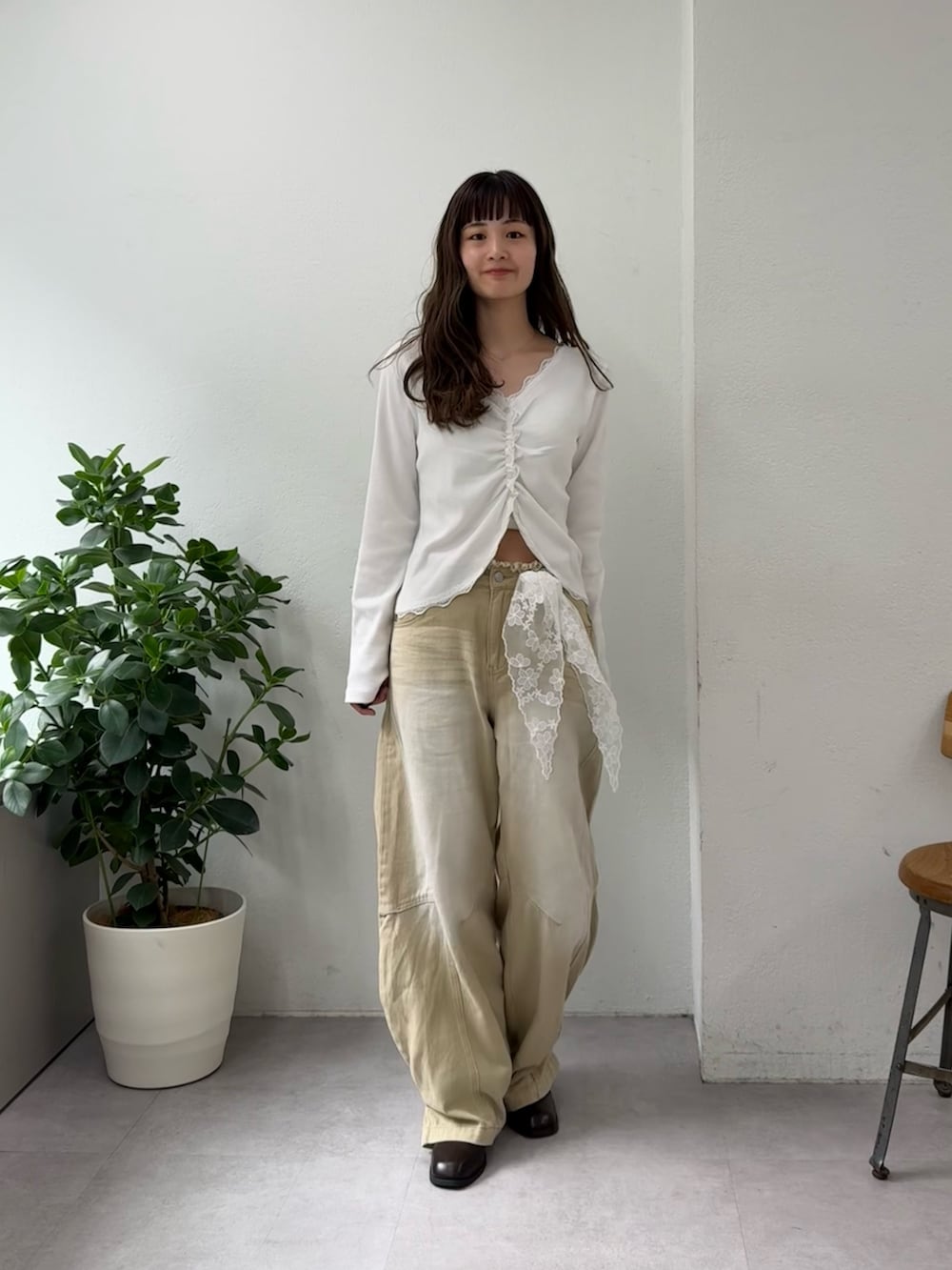 ホワイト系のTシャツ/カットソー、ベージュ系のデニムパンツ、ブラウン系のブーツを着用したレディースの春コーディネートの3枚目の写真