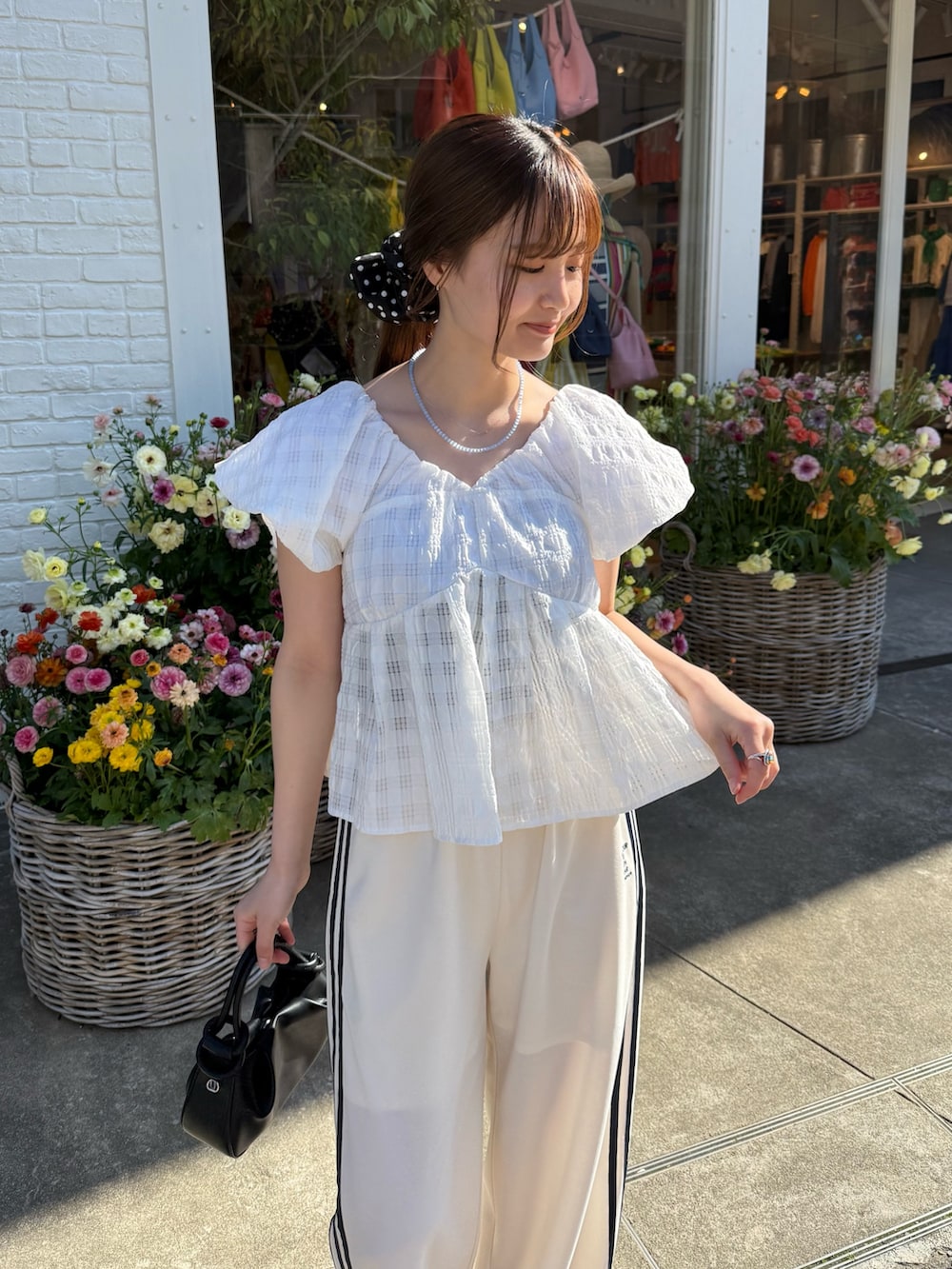 ホワイト系のシャツ/ブラウス、ホワイト系のその他パンツ、ブラック系のトートバッグを着用したレディースの春コーディネートの3枚目の写真