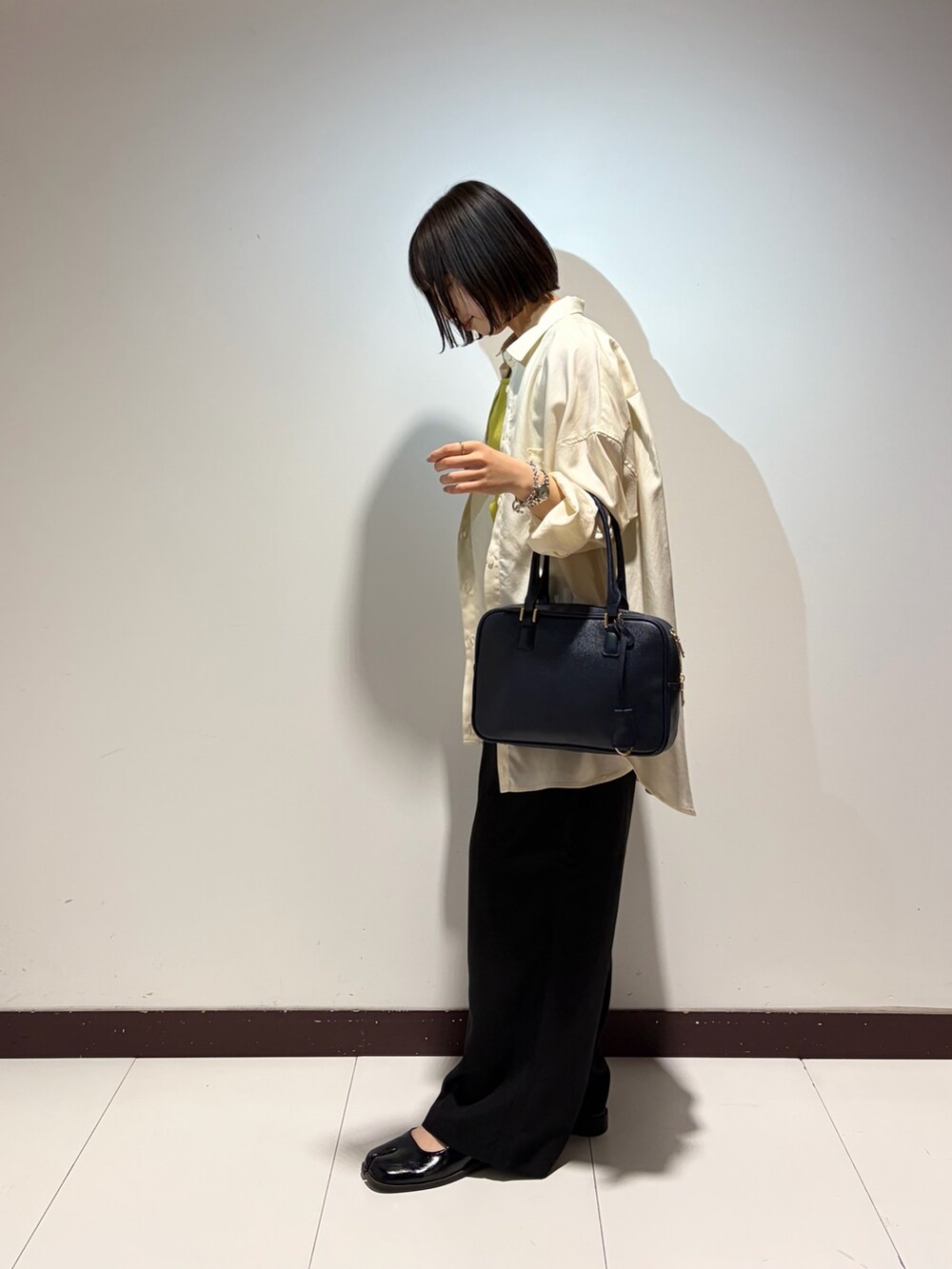 グリーン系のニット/セーター、ホワイト系のシャツ/ブラウス、ブラック系のその他パンツを着用したレディースの夏コーディネートの2枚目の写真