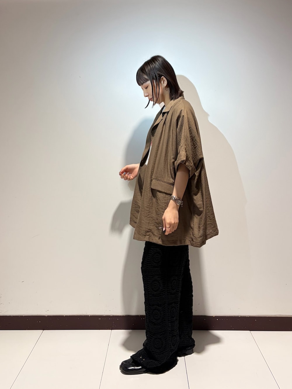 グレー系のTシャツ/カットソー、ブラウン系のその他アウター、グリーン系のショルダーバッグを着用したレディースの夏コーディネートの2枚目の写真