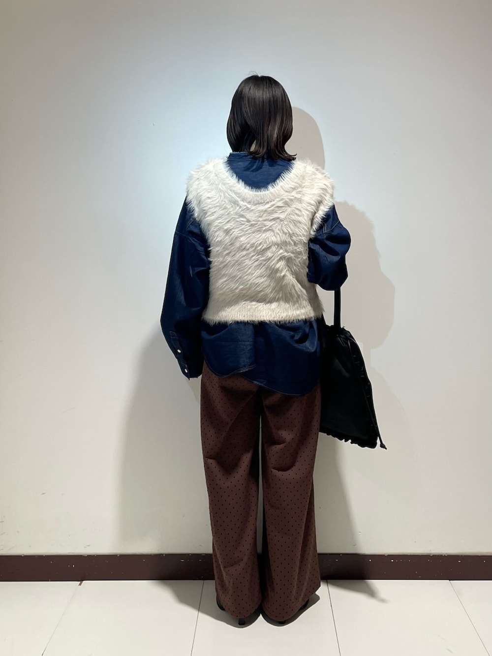 ブルー系のシャツ/ブラウス、グレー系のベスト、ブラウン系のその他パンツを着用したレディースの冬コーディネートの3枚目の写真