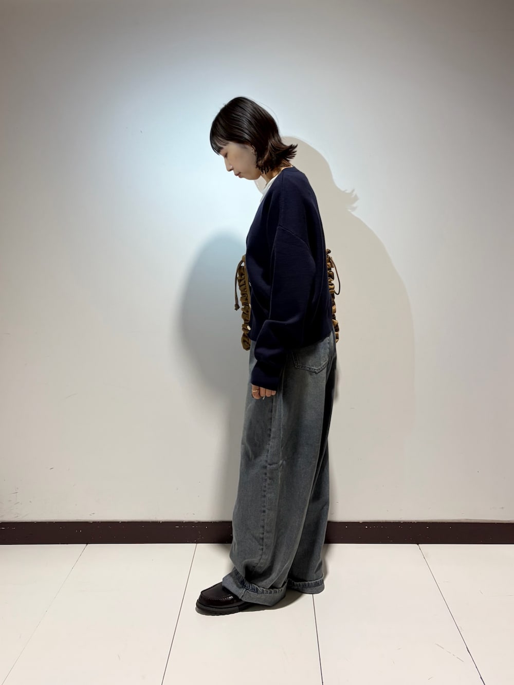 ホワイト系のTシャツ/カットソー、ブルー系のデニムパンツ、ブルー系のニット/セーターを着用したレディースの春コーディネートの2枚目の写真