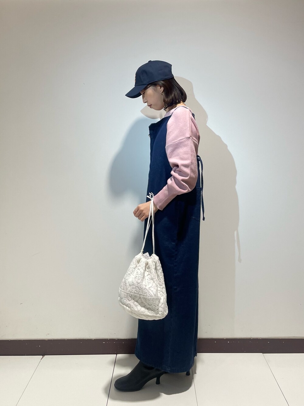 ブルー系のワンピース、ピンク系のニット/セーター、ホワイト系のショルダーバッグを着用したレディースの冬コーディネートの2枚目の写真
