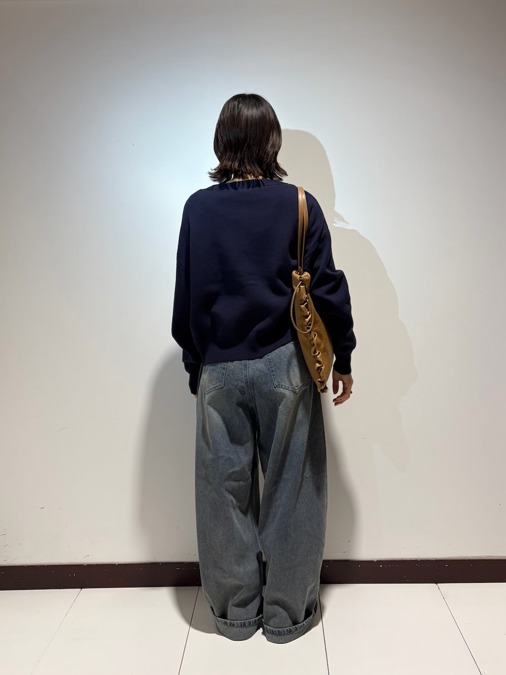 ホワイト系のTシャツ/カットソー、ブルー系のデニムパンツ、ブルー系のニット/セーターを着用したレディースの春コーディネートの3枚目の写真