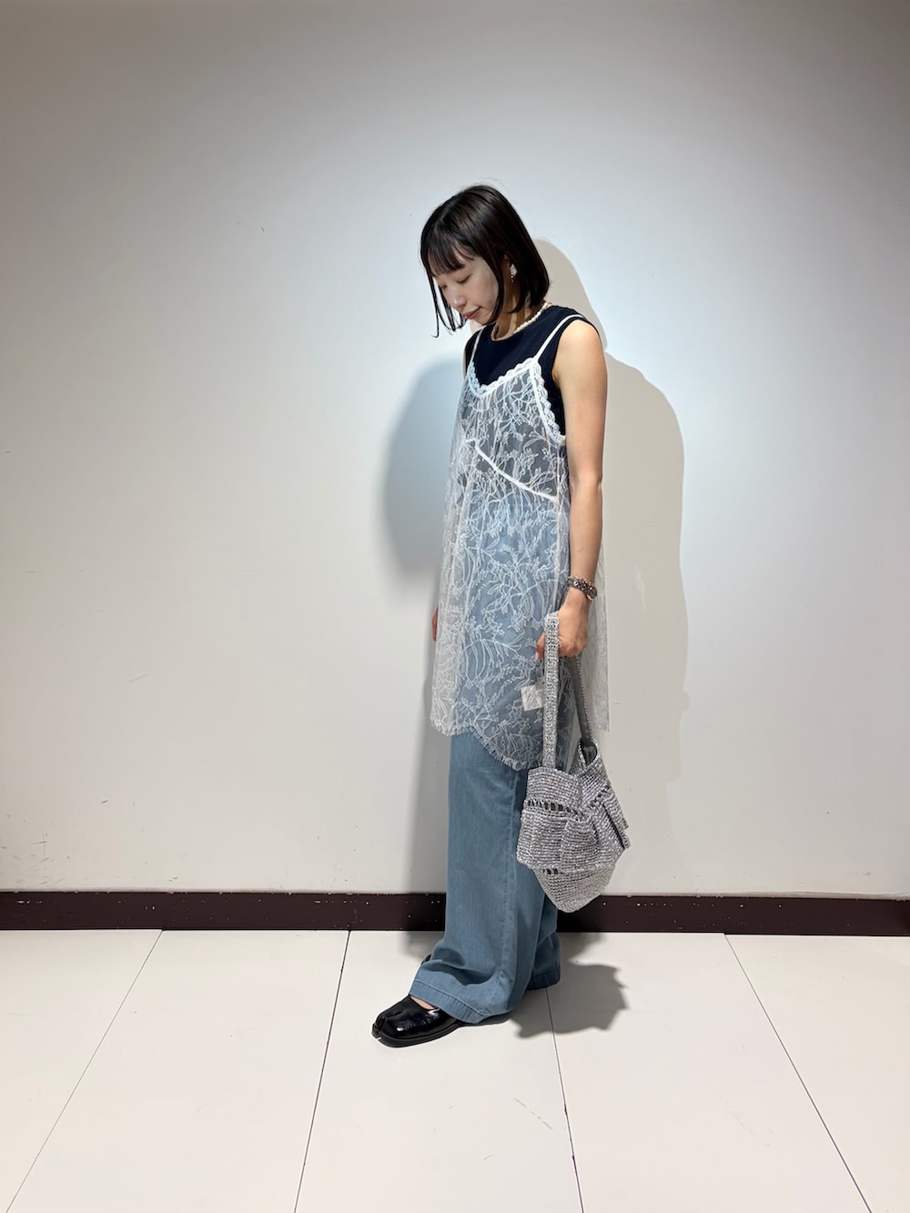 ブルー系のデニムパンツ、ホワイト系のキャミソール、ブルー系のニット/セーターを着用したレディースの夏コーディネートの2枚目の写真