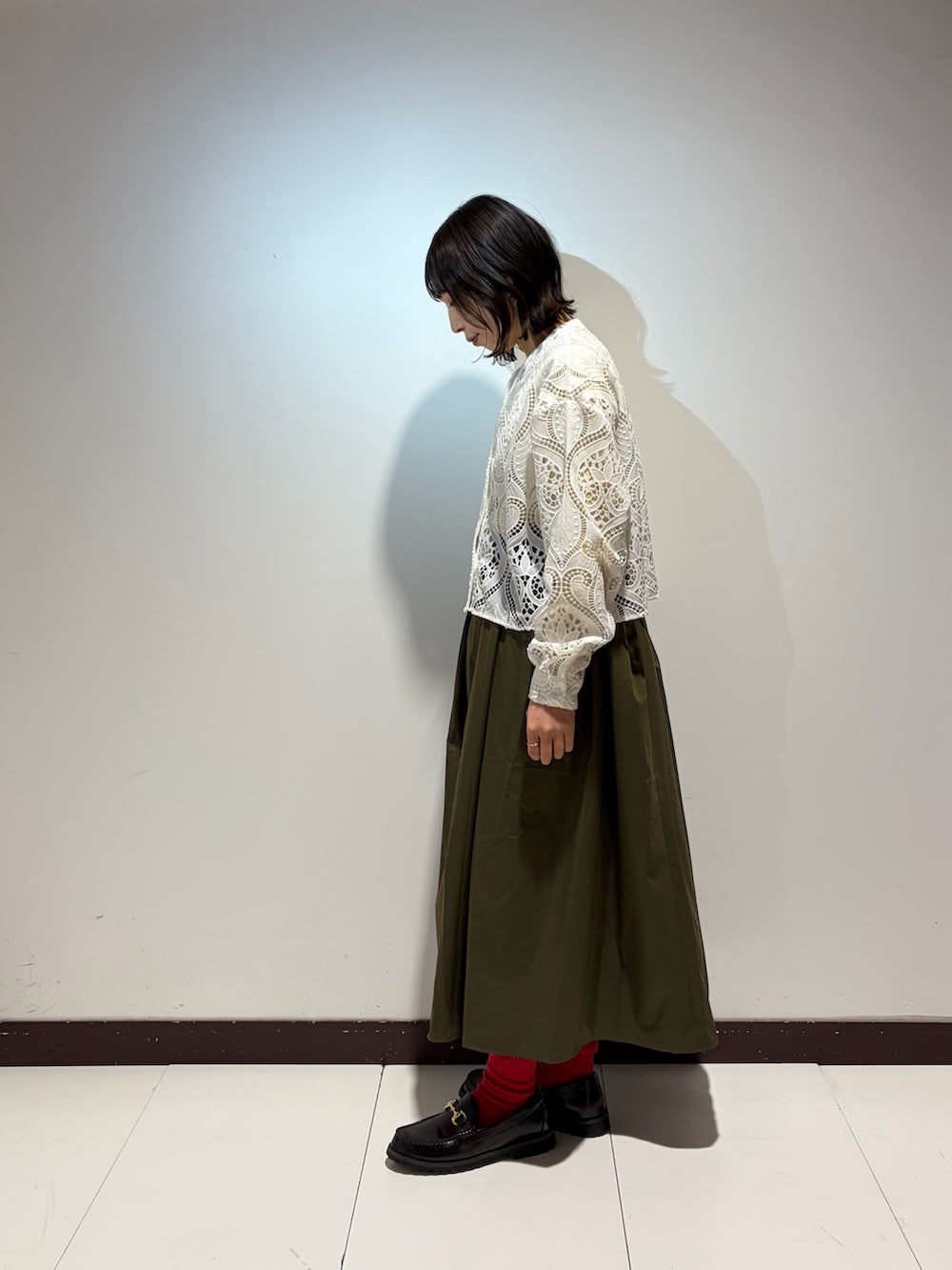 グリーン系のスカート、ホワイト系のシャツ/ブラウスを着用したレディースの春コーディネートの2枚目の写真