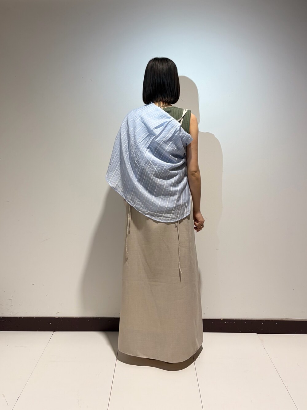 ベージュ系のワンピース、グリーン系のニット/セーター、ブルー系のシャツ/ブラウスを着用したレディースの夏コーディネートの3枚目の写真